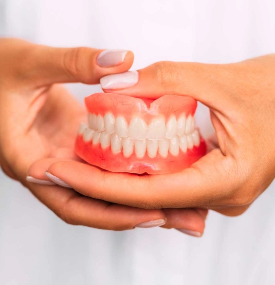 Patient holding a custom digitally designed denture