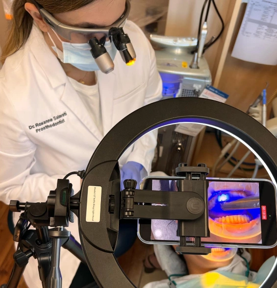 Dentist using digital technology during a no-prep veneer procedure